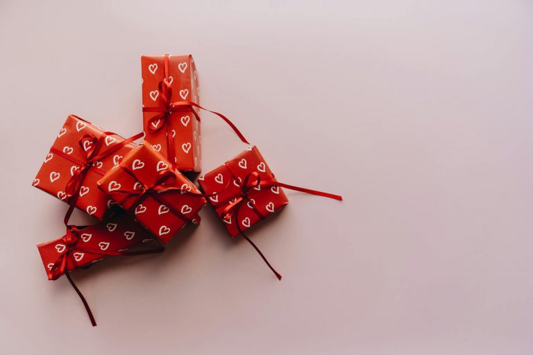 Elegant red gift boxes wrapped with hearts, perfect for Valentine's Day and celebrations.