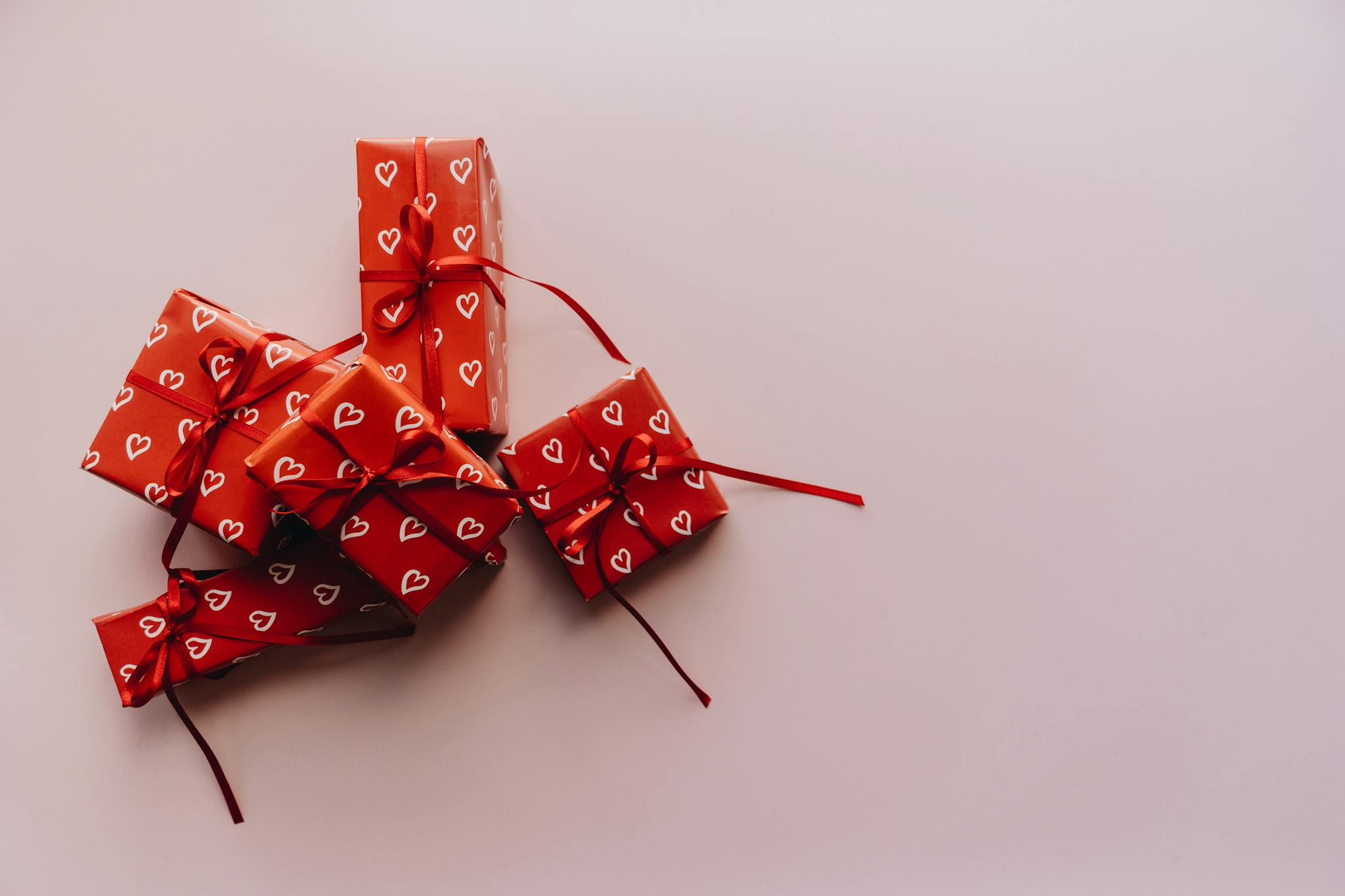 Elegant red gift boxes wrapped with hearts, perfect for Valentine's Day and celebrations.